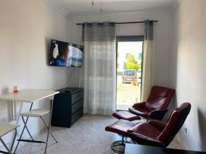 sala de estar con mesa, sillas y TV en Loft valentina en Playa Blanca