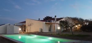 ein Swimmingpool vor einem Haus bei Nacht in der Unterkunft Lispusada Agriturismo Adults Only in Biancareddu
