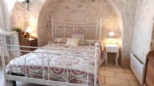 ein Schlafzimmer mit einem Bett und einer Steinmauer in der Unterkunft Casa Ciccone Cardone in Locorotondo