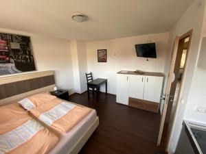 a small bedroom with a bed and a small table at Pension Haselmann in Münster