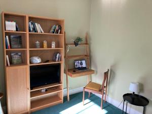 uma sala de estar com televisão e uma estante de livros em Penny End, Mosser - Western Lakes and great walks em Cockermouth