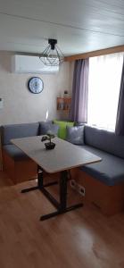 salon ze stołem i kanapą w obiekcie Veni Mobilház w mieście Privlaka