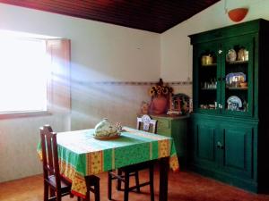a dining room with a table and a green cabinet at Linhal das Meias - São José das Matas in São José +41 photos