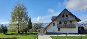 a white house with a gambrel roof at Pr' Koritnek in Bled