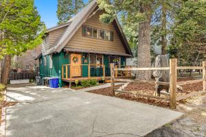 una casa verde con una valla de madera delante de ella en Adorable Explorable, en Lake Arrowhead