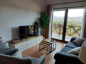 un soggiorno con due divani e una grande finestra di Casa Rural Alta Ladera a Hoyos del Espino
