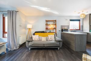a living room with a couch and a kitchen at One Bedroom ground floor flat in Stirling