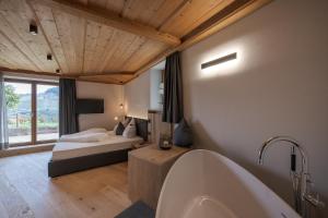 uma casa de banho com uma cama e uma banheira num quarto em Aparthotel Abiná Lana Höhe em Lana