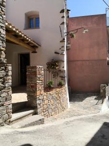 una casa con una puerta y una pared de piedra en Domu Antiga, en Tertenìa