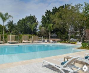 a swimming pool with lounge chairs and trees at Rancho Macloy Hotel Spa & Social Events in Yautepec de Zaragoza