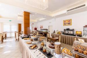 a buffet line with food on display in a restaurant at Hotel Edelweiss Riccione in Riccione