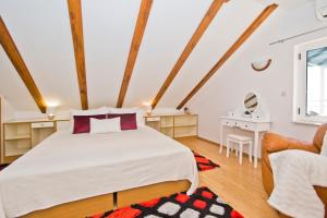 a bedroom with a large bed and a chair at Apartmani Marinka Viskovic in Hvar