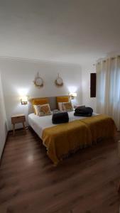 um quarto com uma cama grande com um cobertor amarelo em Meimoa Guesthouse em Meimoa