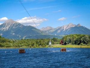 ein Segelboot in einem See mit Bergen im Hintergrund in der Unterkunft Appartement montagne LE FLOCON in Saint-Michel-de-Chaillol