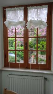 una ventana con cortinas blancas y radiador en Casa Elena II en Lerici
