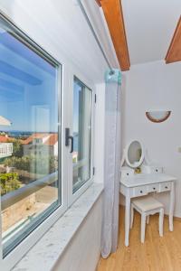 een kamer met een raam, een bureau en uitzicht bij Apartmani Marinka Viskovic in Hvar