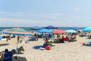 
a beach filled with lots of people and umbrellas at Seagrass Inn in Old Orchard Beach
