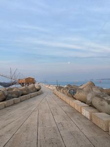 a road with rocks on the side of a beach at Laguna Suite B&B in Chioggia