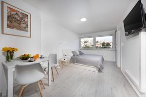 a bedroom with a bed and a desk and a television at Tennis apartment Dubrovnik, FREE parking, beach in Dubrovnik