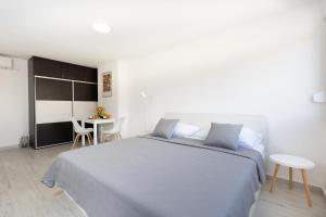 a bedroom with a large bed and a table at Tennis apartment Dubrovnik, FREE parking, beach in Dubrovnik