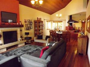 sala de estar con sofá y comedor en Casa MARAVILHOSA com 4 Suítes em Condomínio en Camanducaia