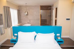 1 cama con cabecero azul en una habitación en South Hands Luxury Rooms, en Nápoles