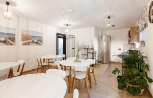 a dining room with white tables and chairs at Villa Natura Rewa in Rewa
