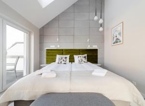 - une chambre avec un grand lit blanc et 2 oreillers dans l'établissement Villa Natura Rewa, à Rewa