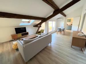 sala de estar con sofá blanco y TV en La Dolce Vita Nîmoise Terrasse 100 m des Arènes en Nimes