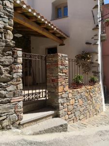 un edificio de piedra con una puerta y una pared de piedra en Domu Antiga, en Tertenìa