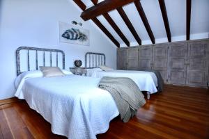 ポテスにあるApartamentos Rurales Valverdeの青い壁とウッドフロアの客室で、ベッド2台が備わります。