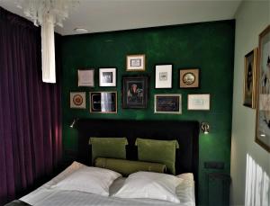 a bedroom with a green wall with a bed at Vinoteegi Residents in Kuressaare
