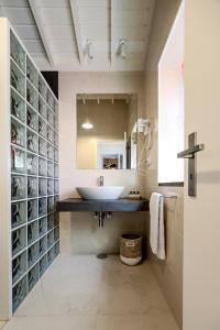 a bathroom with a sink and a mirror at Adega Baía Azul - The essence of Pico in São Roque do Pico