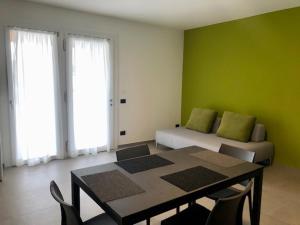 um quarto com uma mesa e uma cama com paredes verdes em Corte Rocchetti Suite em Lazise