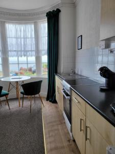 a kitchen with a sink and a table with a table at SeaView ground floor flat fast WiFi & FREE PARKING in Scarborough