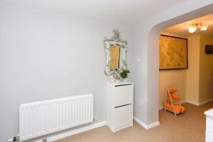 Habitación con tocador blanco y espejo. en Quest Fulfiller - Near hospital Free parking and Garden en Southampton