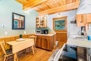 eine Küche mit Holzschränken, einem Tisch, einem Tisch und Stühlen in der Unterkunft Cedar Nook in Arcadia
