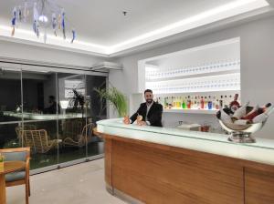 a man sitting at a bar in a restaurant at Hotel Parthenon Rodos city in Rhodes Town