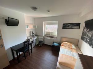 a small room with a bed and a desk at Pension Haselmann in Münster