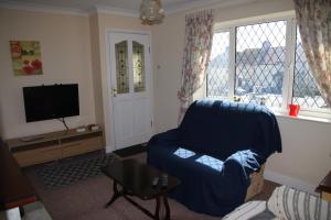 a living room with a blue chair and a tv at The House on the Hill in Kilrush