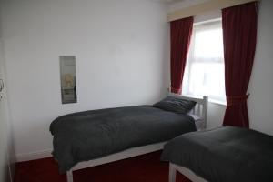 a bedroom with two beds and a window at The House on the Hill in Kilrush