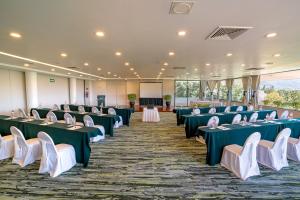 a room with green and white tables and chairs at Hotel Victoria Oaxaca in Oaxaca City