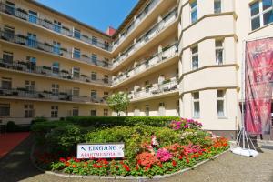 un gran edificio con flores delante en Hotel & Apartments Zarenhof Berlin Prenzlauer Berg, en Berlín