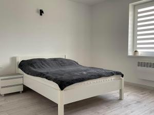 ポジェズドジェにあるNa Końcu Świataの白いベッド(上に黒い毛布付)