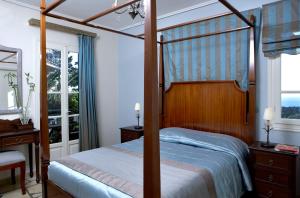 a bedroom with a canopy bed and a window at Dafnoudi Hotel Apartments in Fiskardo +37 photos