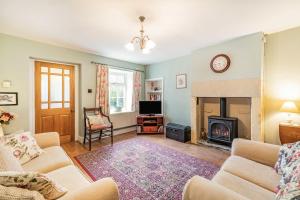 a living room with a couch and a fireplace at Pye Hall Cottage in Silverdale