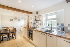 a kitchen with a sink and a counter top at Pye Hall Cottage in Silverdale +13 photos