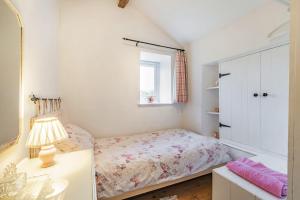 a small bedroom with a bed and a window at Pye Hall Cottage in Silverdale