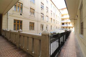 a walkway in front of a building with a fence at Broadway Downtown Deluxe Budapest in Budapest