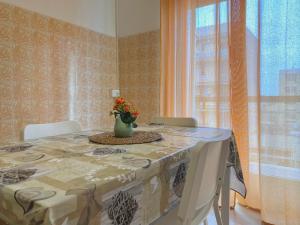 a dining room table with a vase of flowers on it at Guest House Service - Express Airport Apartment in Modugno
